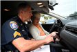 Sergeant Gardner helping a motorist set her vehicle up for hands-free communication at a PD event for the hands-free law