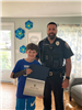 Officer Ruggiero presenting an award to a young local hero