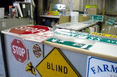 Street signs all over the desk at the sign shop
